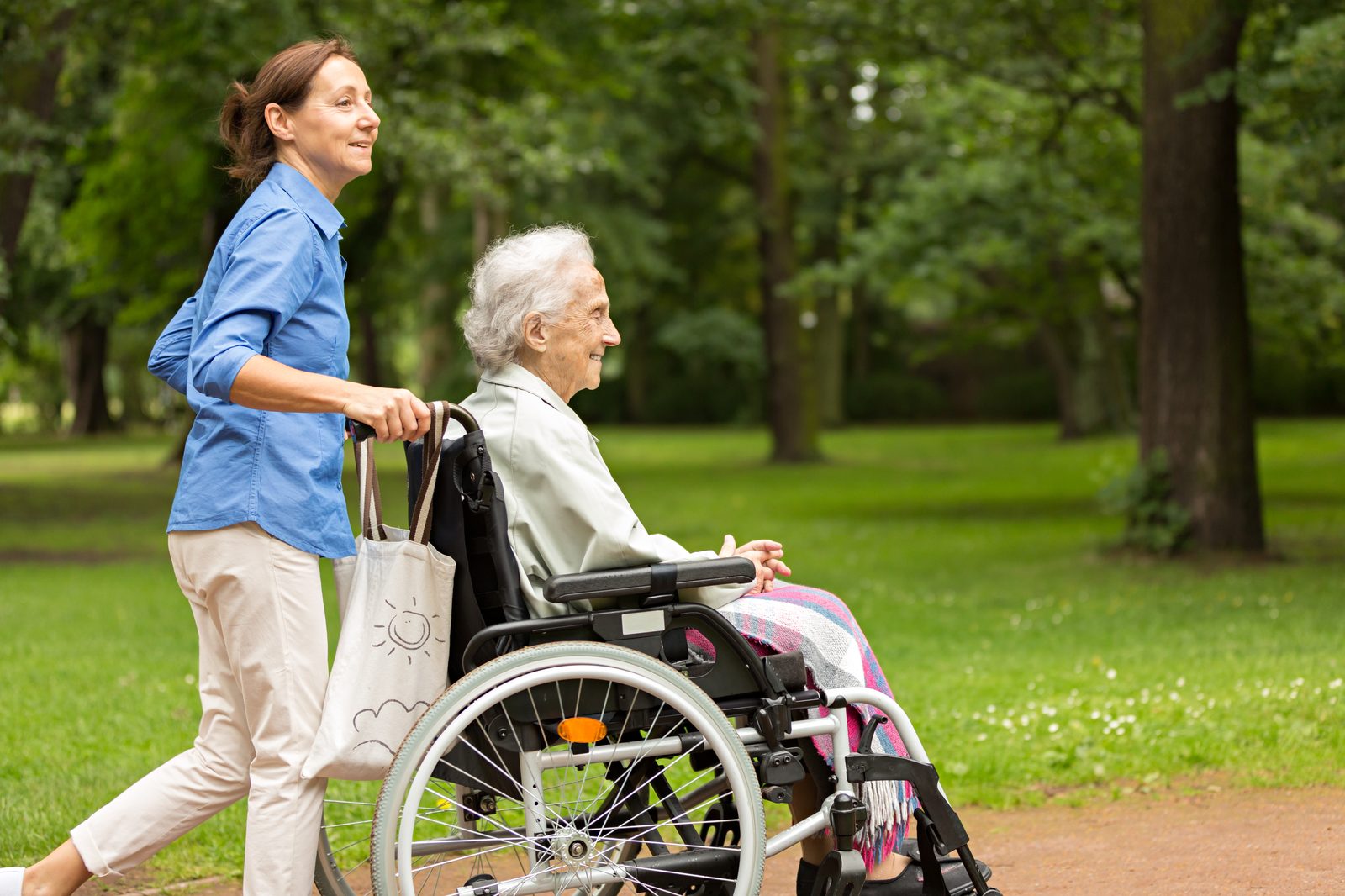 Betreuungskraft begleitet Seniorin beim Spaziergang